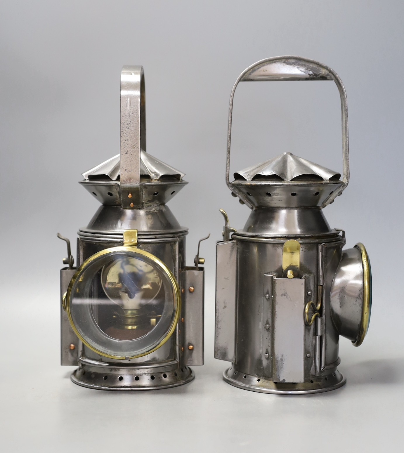 A pair of polished steel lamps, one dated 1945 - 30cm tall